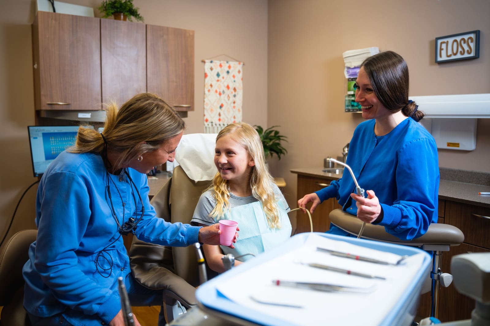 A dental hygienist treating a patient in a treatment room at Dental Associates of Marquette