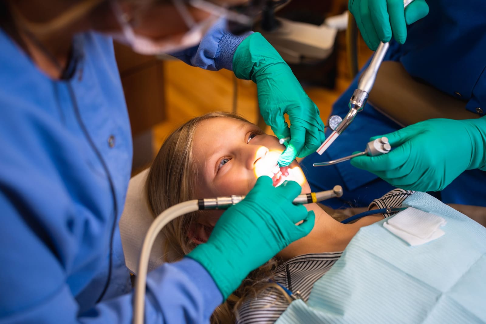 A hygienist reviewing digital x-ray images on a chairside monitor with a patient